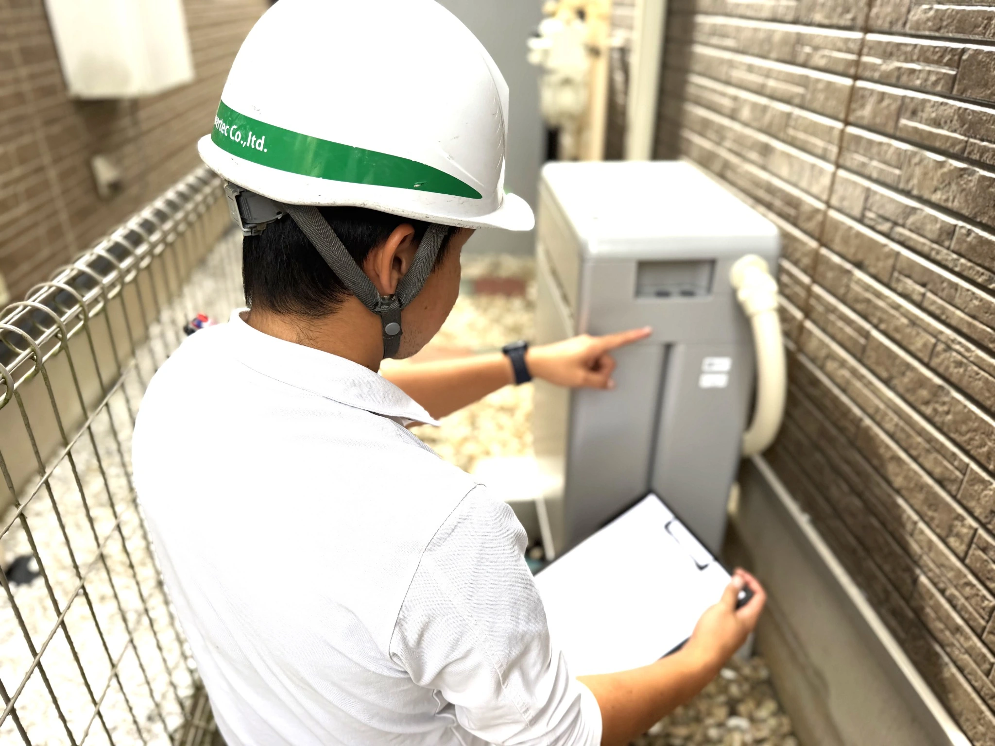 住宅の設備について説明する二和パワーテックのスタッフ